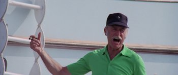 Movie still from “The Day of the Dolphin” (1973), directed by Mike Nichols – An older man wearing a green shirt and a black hat; Close Up shot, Low angle