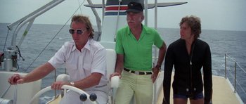 Movie still from “The Day of the Dolphin” (1973), directed by Mike Nichols – Two men are sitting on a boat in the water; Medium shot, Low angle