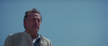 Movie still from “The Day of the Dolphin” (1973), directed by Mike Nichols – A person wearing a suit and tie; Close Up shot, Low angle