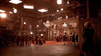 Movie still from “The Day of the Locust” (1975), directed by John Schlesinger – A group of people standing in a large room; Extreme Wide shot, High angle