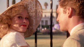 Movie still from “The Day of the Locust” (1975), directed by John Schlesinger – A woman and a man wearing a straw hat; Close Up shot, Over the shoulder angle