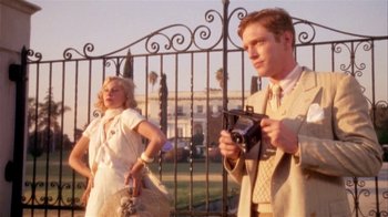 Movie still from “The Day of the Locust” (1975), directed by John Schlesinger – A man and a woman standing in front of a gate; Medium shot, Low angle