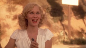 Movie still from “The Day of the Locust” (1975), directed by John Schlesinger – A woman with blonde hair holding a cell phone; Close Up shot, Low angle