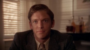 Movie still from “The Day of the Locust” (1975), directed by John Schlesinger – A person wearing a suit and tie; Close Up shot, Over the shoulder angle