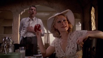 Movie still from “The Day of the Locust” (1975), directed by John Schlesinger – A man and a woman sitting at a dinner table; Medium shot, Low angle