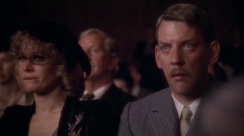 Movie still from “The Day of the Locust” (1975), directed by John Schlesinger – A person wearing a suit and tie; Close Up shot, Low angle