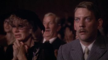 Movie still from “The Day of the Locust” (1975), directed by John Schlesinger – A group of people standing in front of a crowd; Close Up shot, Over the shoulder angle