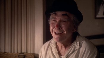 Movie still from “The Day of the Locust” (1975), directed by John Schlesinger – An old man wearing a black hat with a clown nose; Close Up shot, Low angle