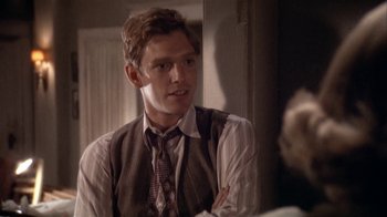 Movie still from “The Day of the Locust” (1975), directed by John Schlesinger – A man in a tie and vest is looking at the camera; Close Up shot, Over the shoulder angle