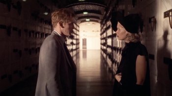 Movie still from “The Day of the Locust” (1975), directed by John Schlesinger – A man and a woman are standing in a hallway; Medium shot, Over the shoulder angle