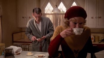 Movie still from “The Day of the Locust” (1975), directed by John Schlesinger – A man and a woman sitting at a table drinking tea; Medium shot, High angle