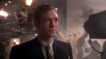 Movie still from “The Day of the Locust” (1975), directed by John Schlesinger – A man wearing a suit and tie in front of a crowd; Close Up shot, Low angle