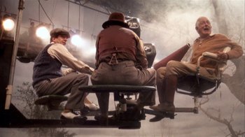 Movie still from “The Day of the Locust” (1975), directed by John Schlesinger – A group of people sitting on top of an amusement park ride; Wide shot, Low angle