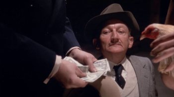 Movie still from “The Day of the Locust” (1975), directed by John Schlesinger – An old man in a hat is holding a bunch of money; Close Up shot, Low angle