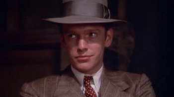 Movie still from “The Day of the Locust” (1975), directed by John Schlesinger – A man wearing a suit and a hat; Close Up shot, High angle