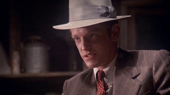 Movie still from “The Day of the Locust” (1975), directed by John Schlesinger – A person wearing a suit and a hat; Close Up shot, Low angle