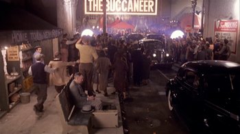 Movie still from “The Day of the Locust” (1975), directed by John Schlesinger – A crowd of people standing around a street; Wide shot, High angle