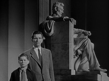 Movie still from “The Day the Earth Stood Still” (1951), directed by Robert Wise – A man and a young boy standing in front of a statue of abraham lincoln; Medium shot, Low angle