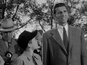 Movie still from “The Day the Earth Stood Still” (1951), directed by Robert Wise – A man standing next to another man wearing a suit; Medium shot, Low angle