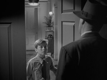 Movie still from “The Day the Earth Stood Still” (1951), directed by Robert Wise – A young boy wearing a suit and tie talking to an older man; Medium shot, Over the shoulder angle