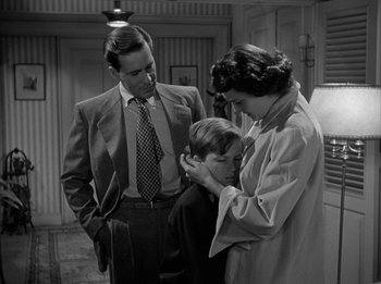 Movie still from “The Day the Earth Stood Still” (1951), directed by Robert Wise – A man and a woman holding a young boy's head; Medium shot, High angle