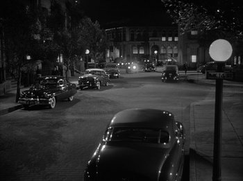 Movie still from “The Day the Earth Stood Still” (1951), directed by Robert Wise – A black and white photo of cars parked on the side of the road; Extreme Wide shot, High angle