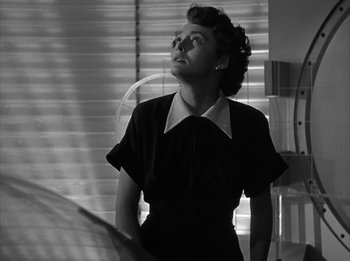 Movie still from “The Day the Earth Stood Still” (1951), directed by Robert Wise – An old photo of a woman in a black dress looking up; Medium shot, Low angle