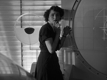 Movie still from “The Day the Earth Stood Still” (1951), directed by Robert Wise – A black and white photo of a woman standing in front of a mirror; Medium shot, Low angle