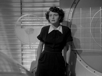 Movie still from “The Day the Earth Stood Still” (1951), directed by Robert Wise – A woman in a black dress standing next to a wall; Medium shot, Low angle