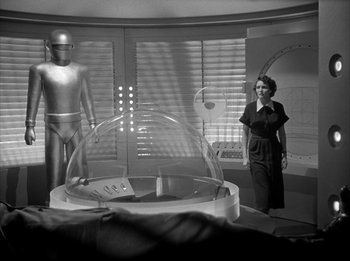 Movie still from “The Day the Earth Stood Still” (1951), directed by Robert Wise – A black and white photo of a woman and a robot; Wide shot, Low angle