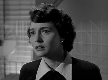 Movie still from “The Day the Earth Stood Still” (1951), directed by Robert Wise – A woman in a suit and tie looking to her left; Close Up shot, Low angle