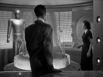 Movie still from “The Day the Earth Stood Still” (1951), directed by Robert Wise – A man and a woman standing in front of a glass display; Wide shot, Low angle