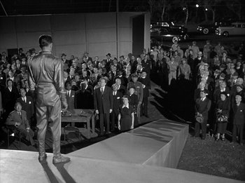 Movie still from “The Day the Earth Stood Still” (1951), directed by Robert Wise – A group of people in suits and ties standing in front of a crowd; Extreme Wide shot, High angle