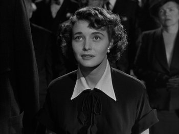 Movie still from “The Day the Earth Stood Still” (1951), directed by Robert Wise – An old black and white photo of a woman in front of a group of people; Close Up shot, Low angle
