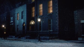 Movie still from “The Dead” (1987), directed by John Huston – A street light in front of a building at night; Extreme Wide shot, Low angle