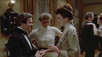 Movie still from “The Dead” (1987), directed by John Huston – Two women and a man in formal wear standing next to each other; Medium shot, High angle