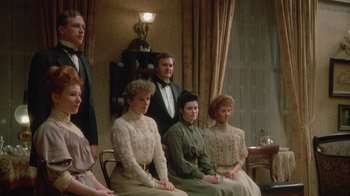 Movie still from “The Dead” (1987), directed by John Huston – A group of people sitting in a living room together; Medium shot, Low angle