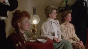 Movie still from “The Dead” (1987), directed by John Huston – A group of women sitting next to each other on a chair; Medium shot, Low angle