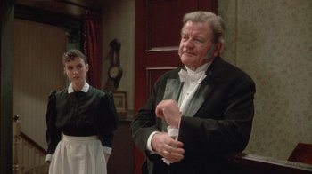 Movie still from “The Dead” (1987), directed by John Huston – An older man in a tuxedo and a young woman in a white dress; Medium shot, Low angle