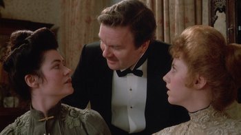 Movie still from “The Dead” (1987), directed by John Huston – Two women and a man in a tuxedo talking to each other; Close Up shot, Over the shoulder angle