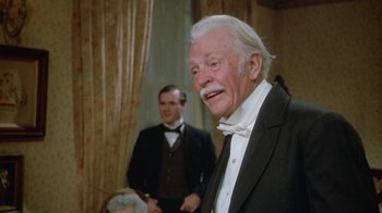 Movie still from “The Dead” (1987), directed by John Huston – An older man wearing a suit and a bow tie; Close Up shot, Over the shoulder angle