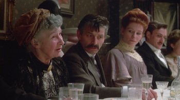 Movie still from “The Dead” (1987), directed by John Huston – A group of people sitting at a dinner table; Close Up shot, Over the shoulder angle