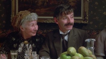 Movie still from “The Dead” (1987), directed by John Huston – An older man and woman sitting in front of a table; Close Up shot, Over the shoulder angle