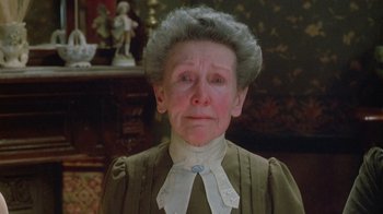 Movie still from “The Dead” (1987), directed by John Huston – An old woman with a sad look on her face; Close Up shot, High angle