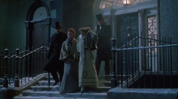 Movie still from “The Dead” (1987), directed by John Huston – A group of people walking down a set of stairs; Wide shot, Low angle