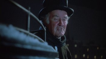 Movie still from “The Dead” (1987), directed by John Huston – An old man wearing a top hat and a scarf; Close Up shot, Low angle