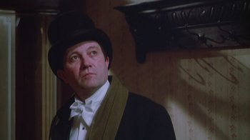 Movie still from “The Dead” (1987), directed by John Huston – A man wearing a top hat and a bow tie; Close Up shot, Low angle