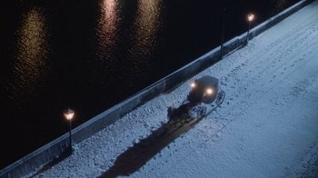 Movie still from “The Dead” (1987), directed by John Huston – An overhead view of a car parked on the side of the road; Extreme Wide shot, High angle