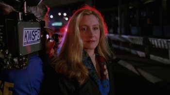 Movie still from “The Dead Pool” (1988), directed by Buddy Van Horn – A woman with long blonde hair standing next to a camera; Close Up shot, Over the shoulder angle