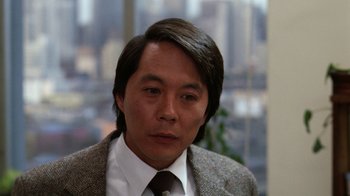 Movie still from “The Dead Pool” (1988), directed by Buddy Van Horn – A person wearing a suit and tie; Close Up shot, Over the shoulder angle